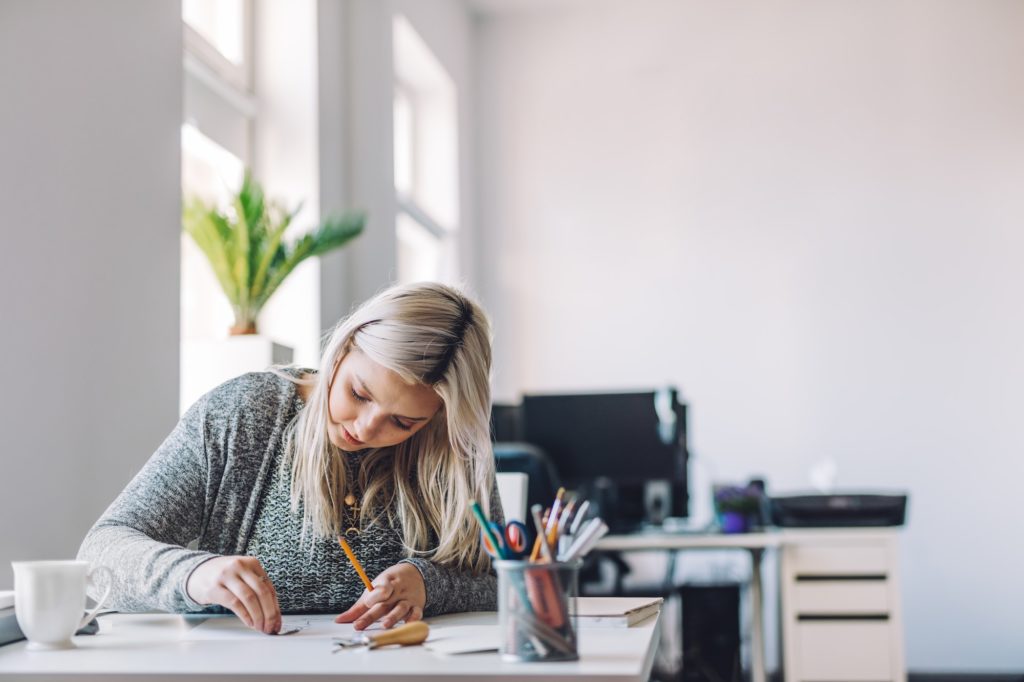 Positive woman doing linearity and first sketches in office